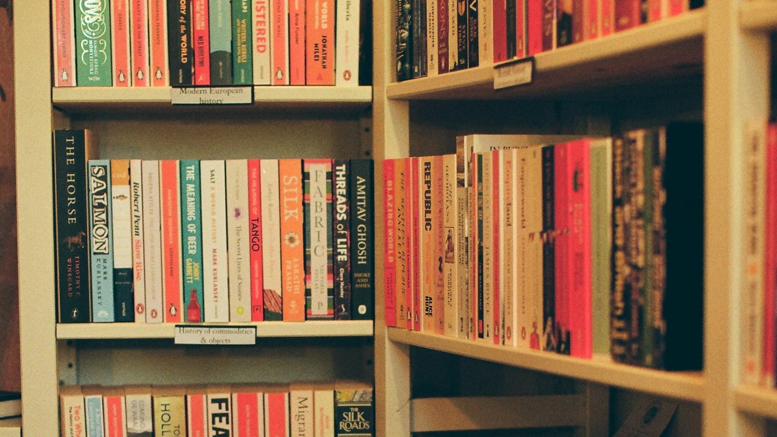 Books neatly arranged on warm-toned shelves, suggesting a library of helpful resources