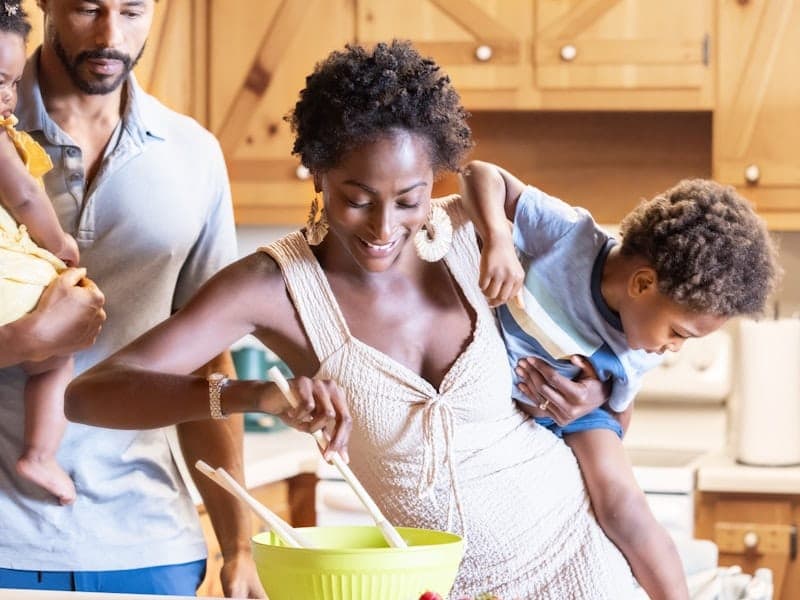A family cooking together in a bright, sunlit kitchen