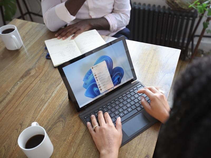 Overhead view of two people working calmly at a table with a laptop and notebook